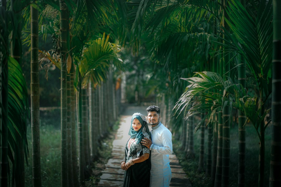 Couple standing on a path lined with palm trees