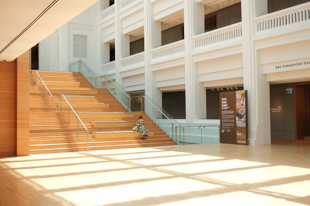 A person walks up wooden stairs in a modern building.