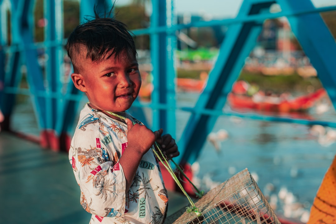 A young boy with a cage on his shoulder