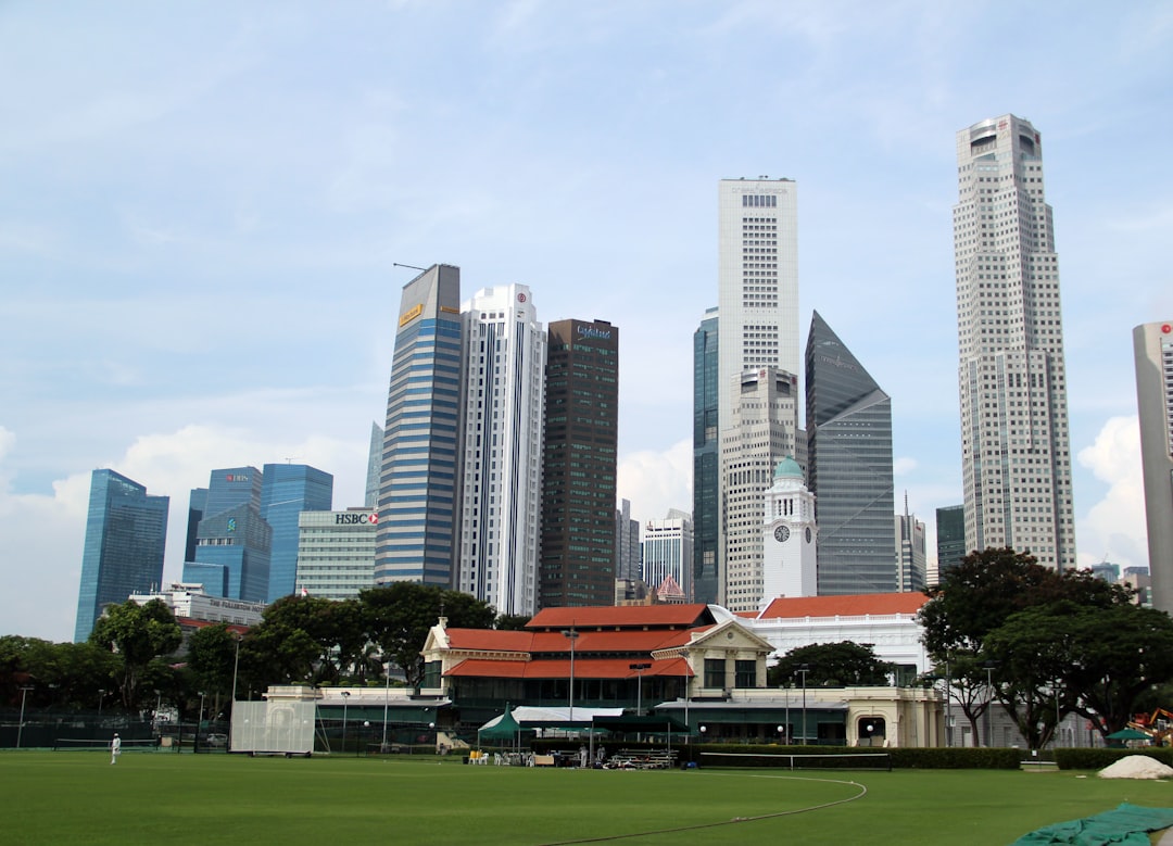 white and gray concrete building near green grass field under white sky during daytime