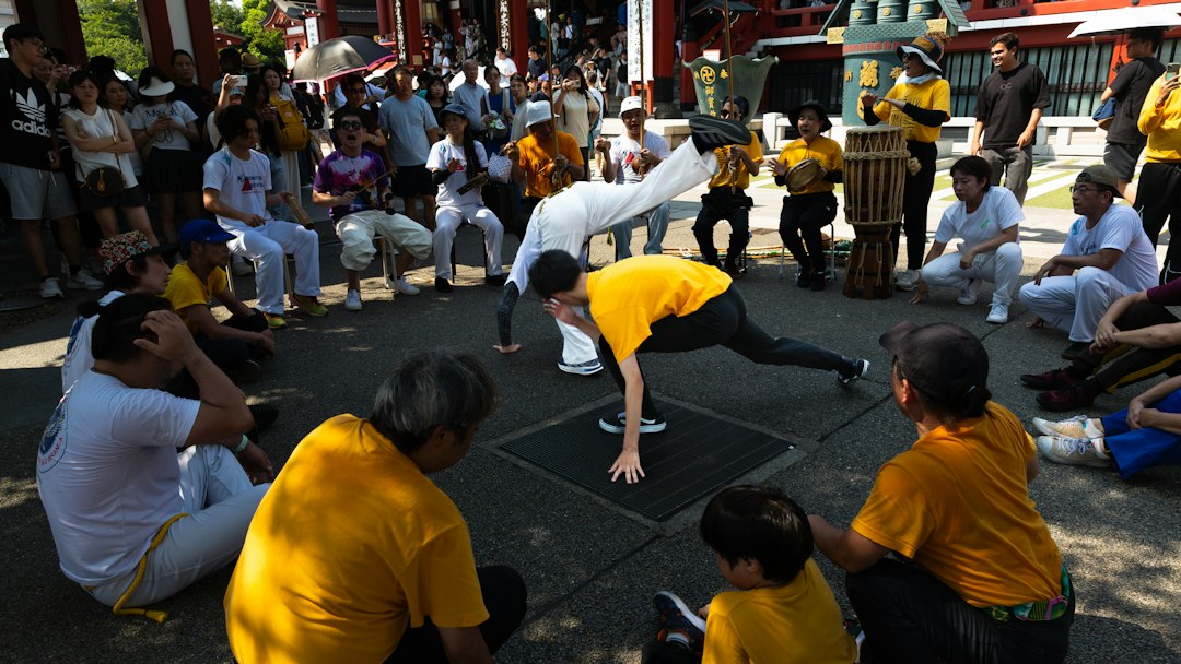 People watch capoeira performers in a circle outdoors