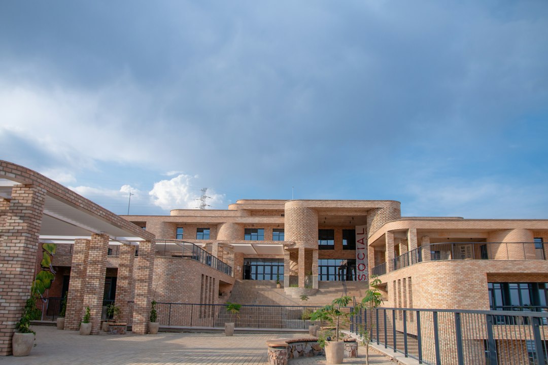 Modern brick architecture with multiple levels and a cloudy sky