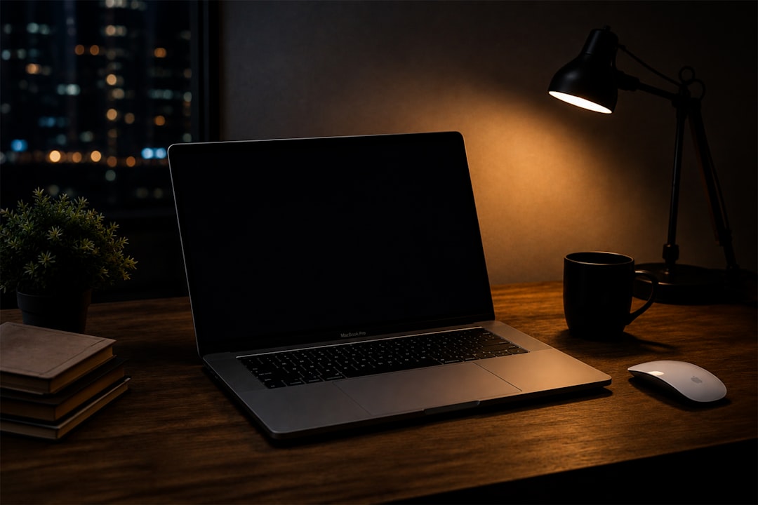 Nighttime desk setup with laptop, lamp, and city lights.