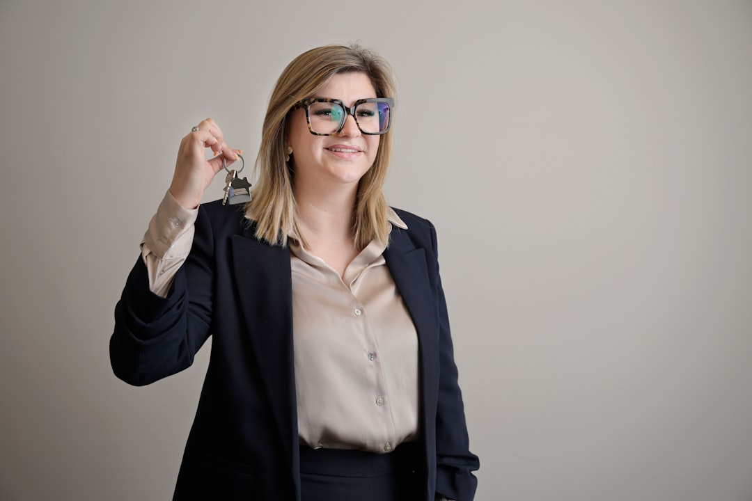 Professional woman smiling and presenting a set of keys.
