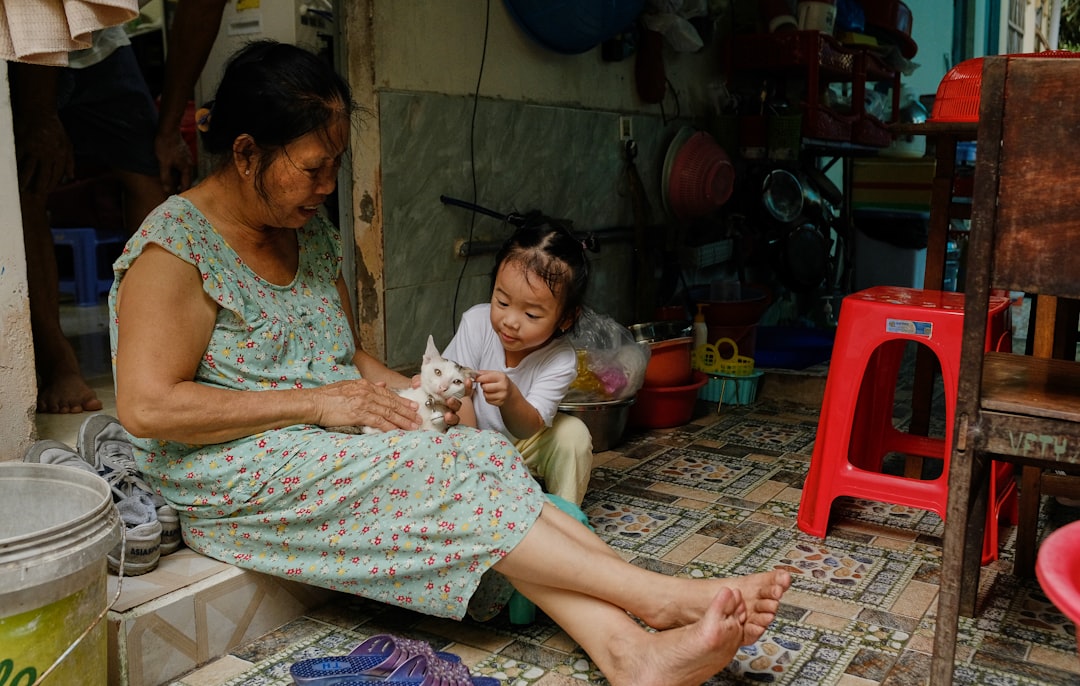 Grandmother and child petting a white cat