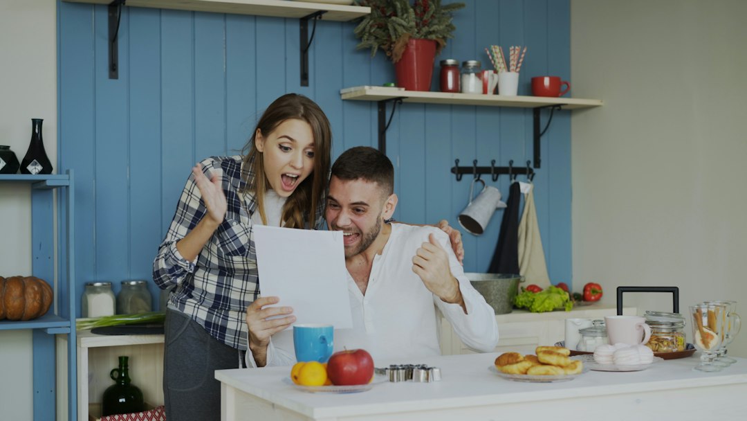 Couple celebrating good news while looking at paper