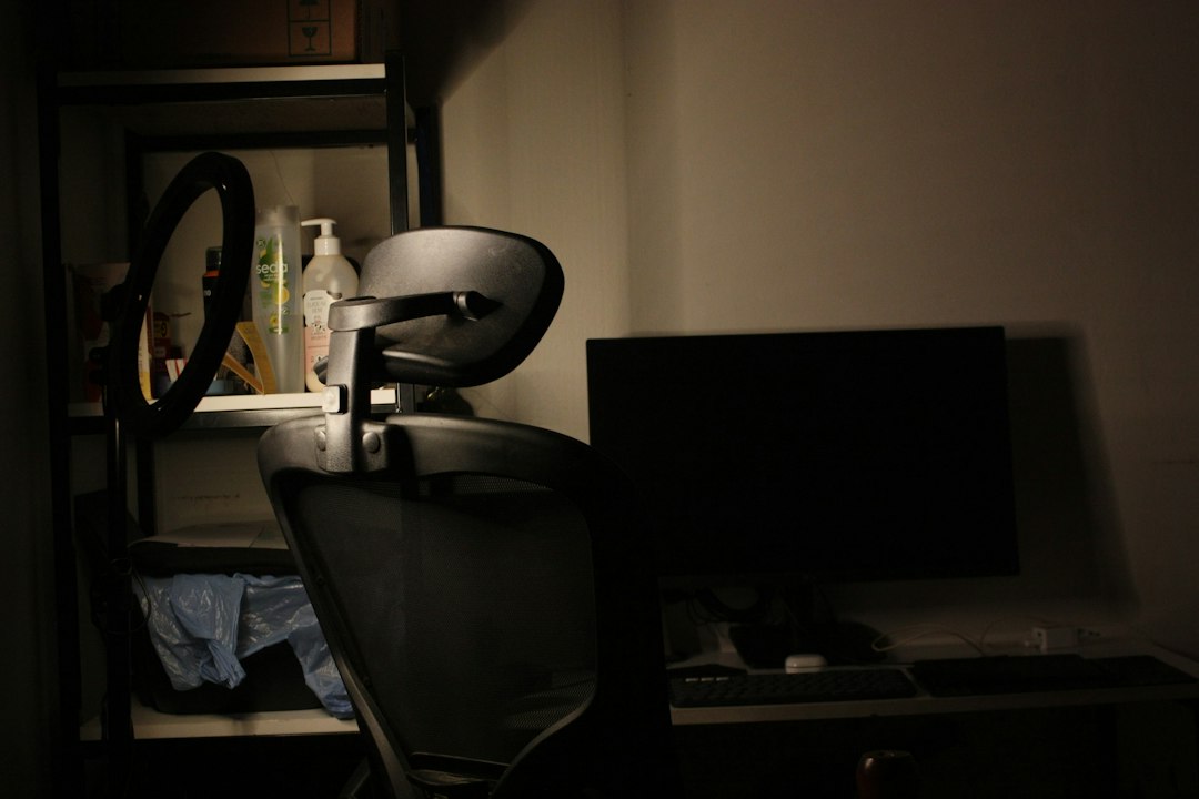 Desk with chair and computer in dim lighting