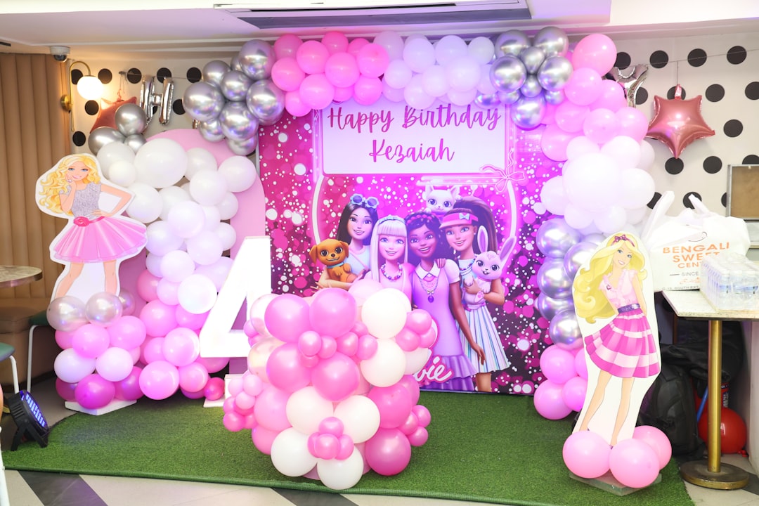 Barbie themed birthday party decoration with pink and silver balloons.