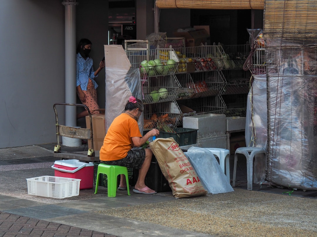 man in blue polo shirt and white pants holding brown plastic bag