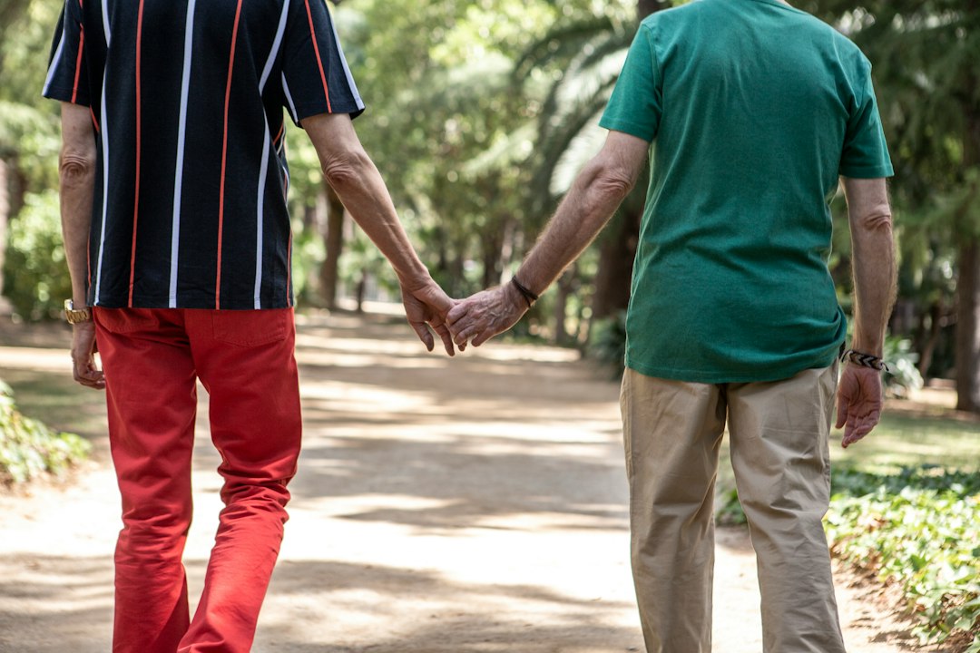 A man and a woman holding hands walking down a path