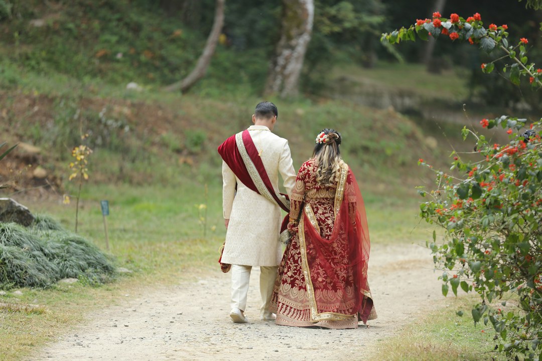 Newlyweds walk hand-in-hand on a dirt path