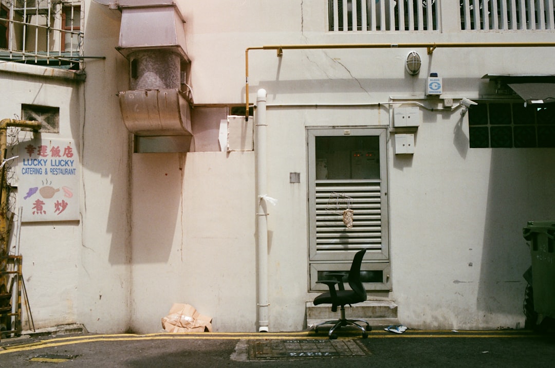 a black chair sitting in front of a white building