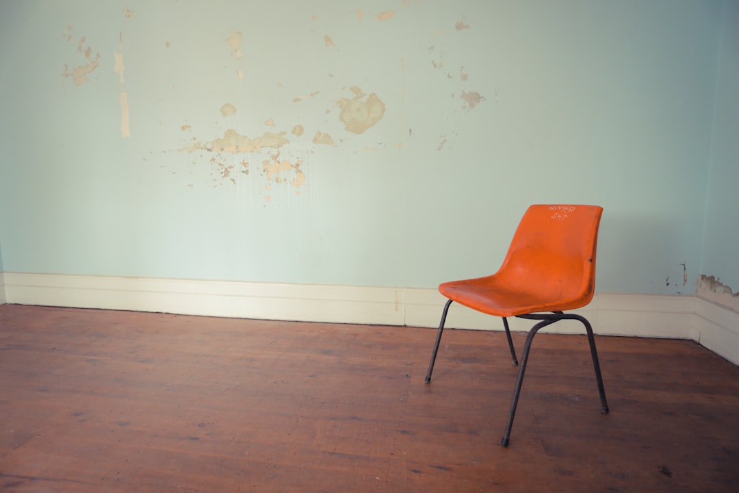 orange and black chair near wall