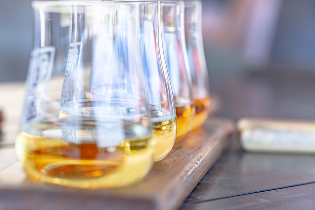 Three beakers with yellow liquid on wooden board