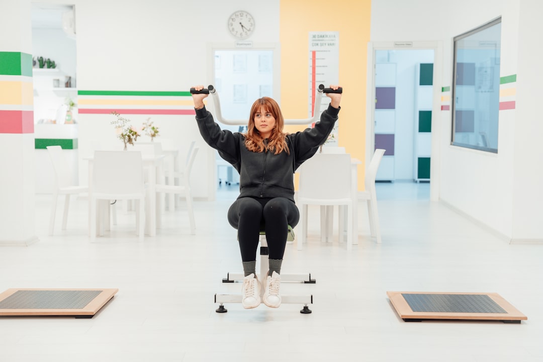 a woman is sitting on a chair with her hands in the air