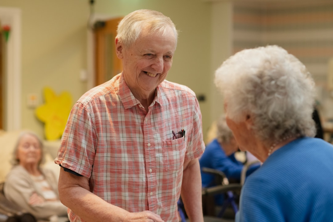 Two smiling seniors talking in a common room.