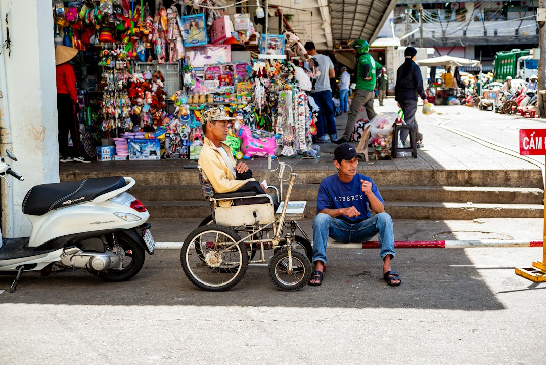 A man sits in a wheelchair on the street