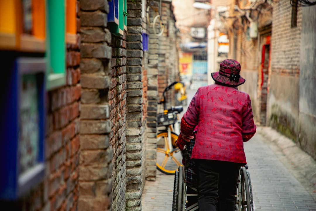 a woman riding a bike down a narrow street