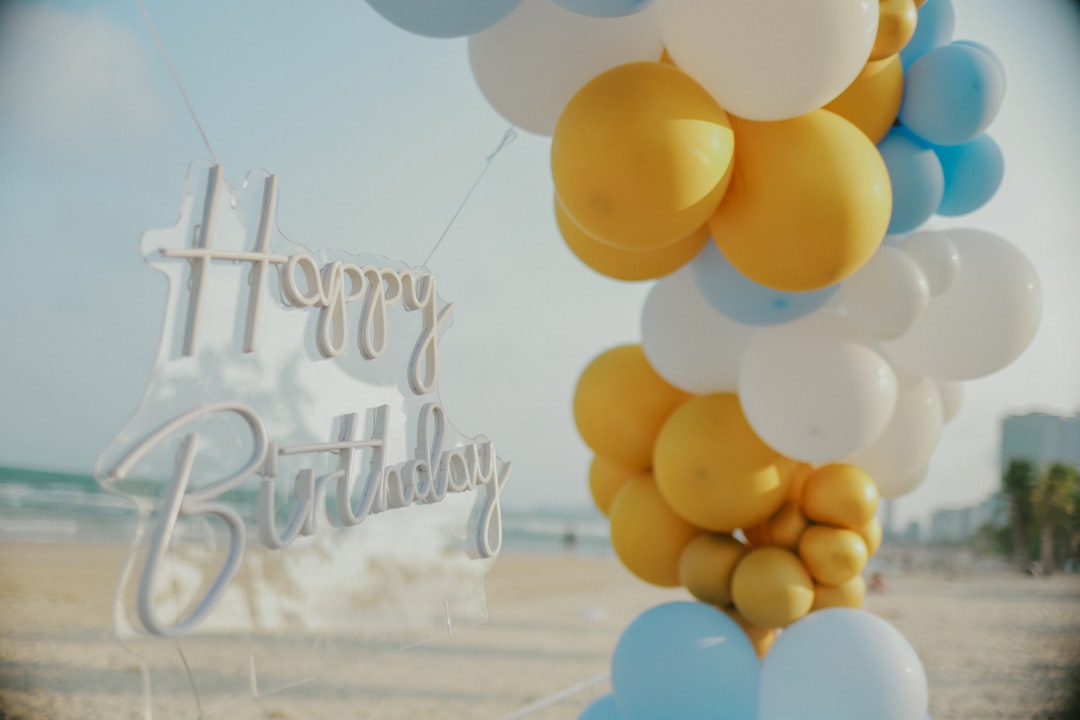 Happy birthday sign with balloons on a beach