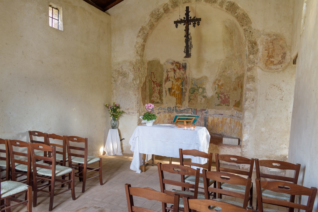 Small chapel interior with altar and wooden chairs.