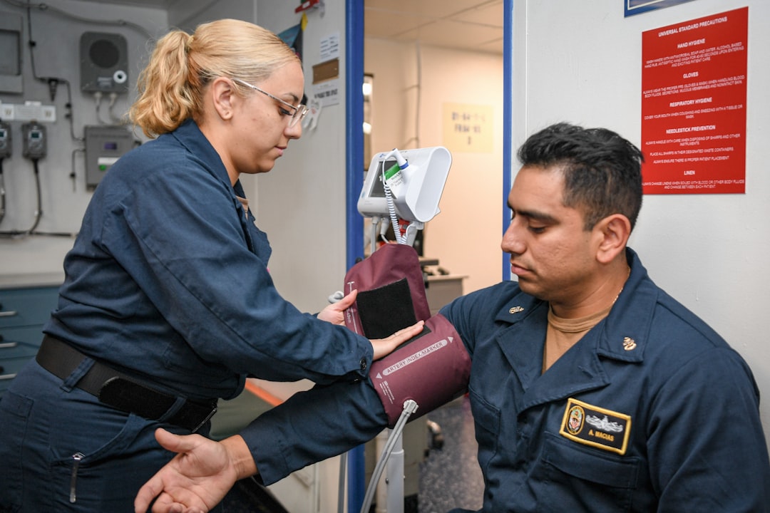 Medical professional taking a sailor's blood pressure.