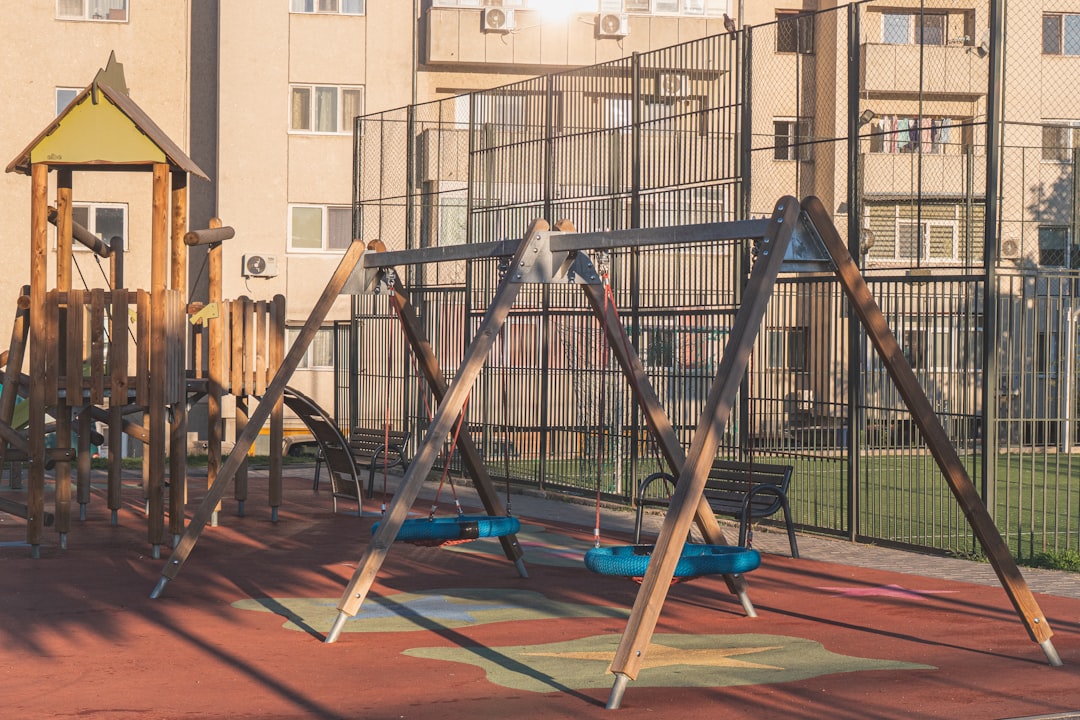 Wooden playground with swings and climbing structure.