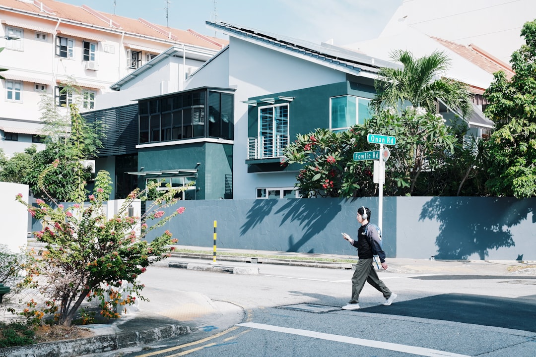 Person crossing street in front of modern house