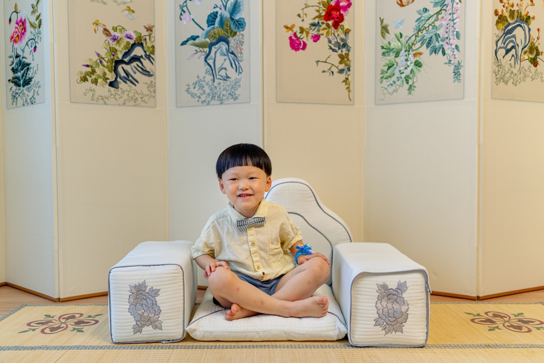 boy in white t-shirt sitting on white sofa