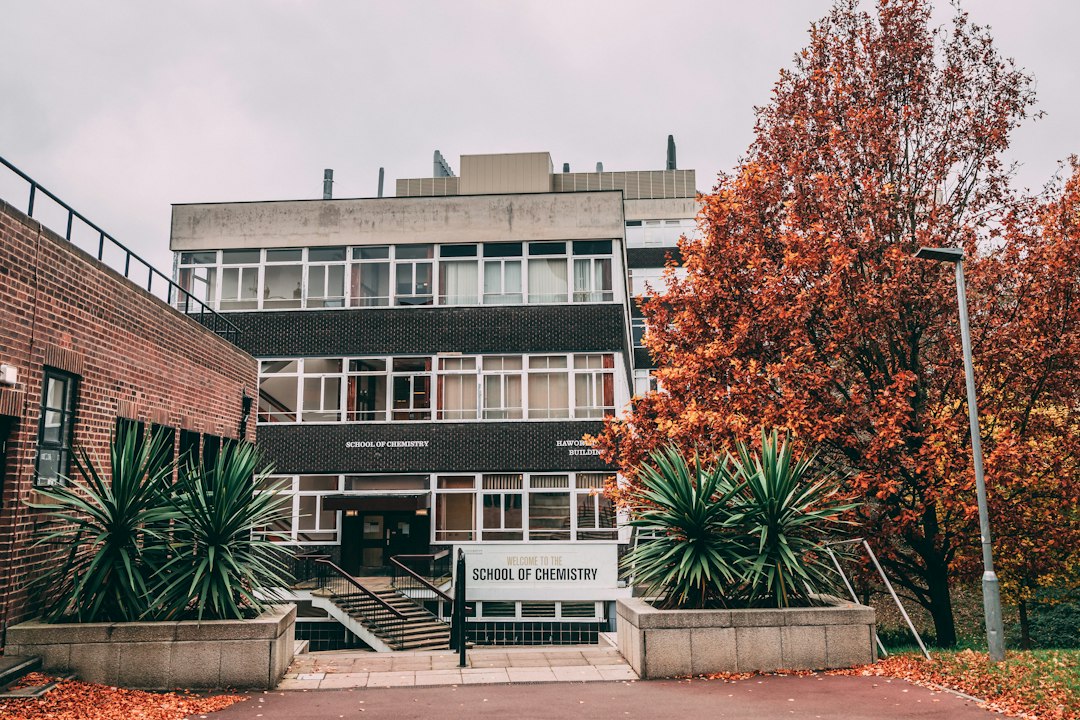 a building with a sign and some plants in front of it