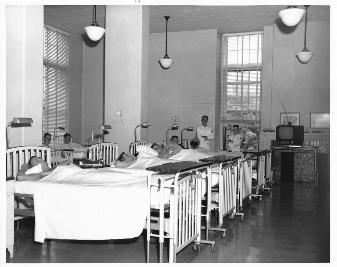 Patients in hospital beds with nurses nearby