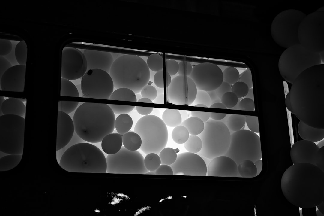 Balloons fill a window at night.
