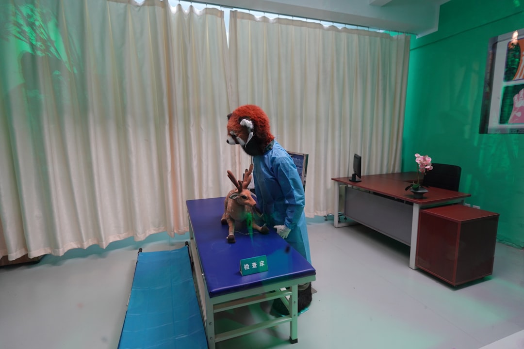 A person in a red panda mask and blue scrubs examining a toy deer