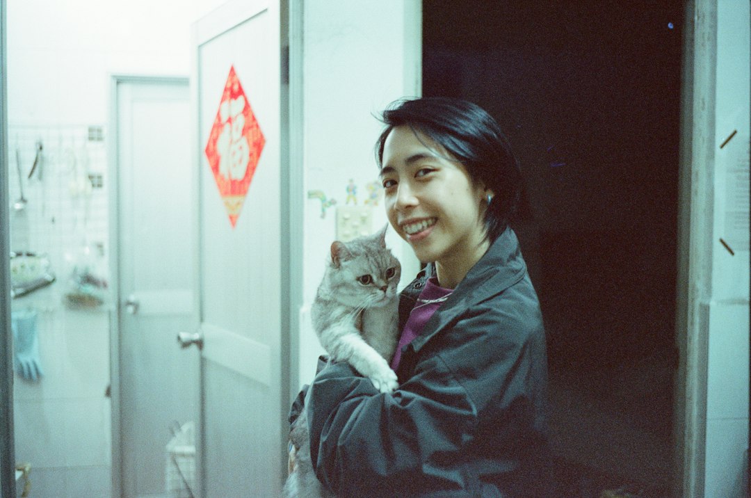 A woman holds a fluffy cat indoors