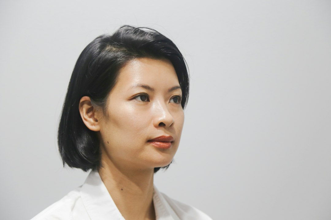 a woman with short black hair and a white shirt