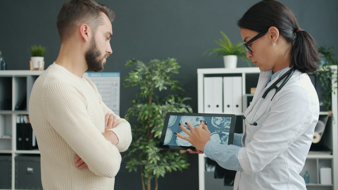 Doctor shows patient medical scan on tablet