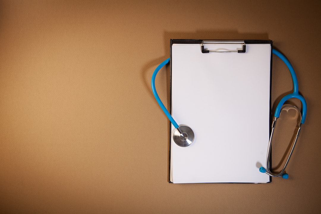 Clipboard with stethoscope on a brown background