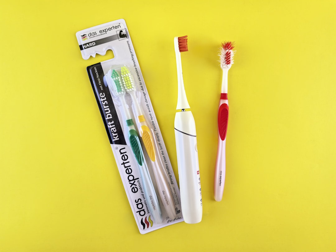 Two toothbrushes and packaging on yellow background