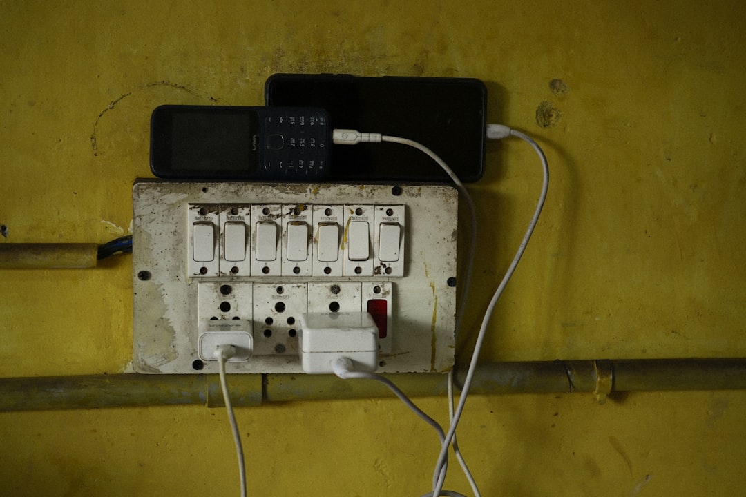 Phones are charging on an electrical outlet.